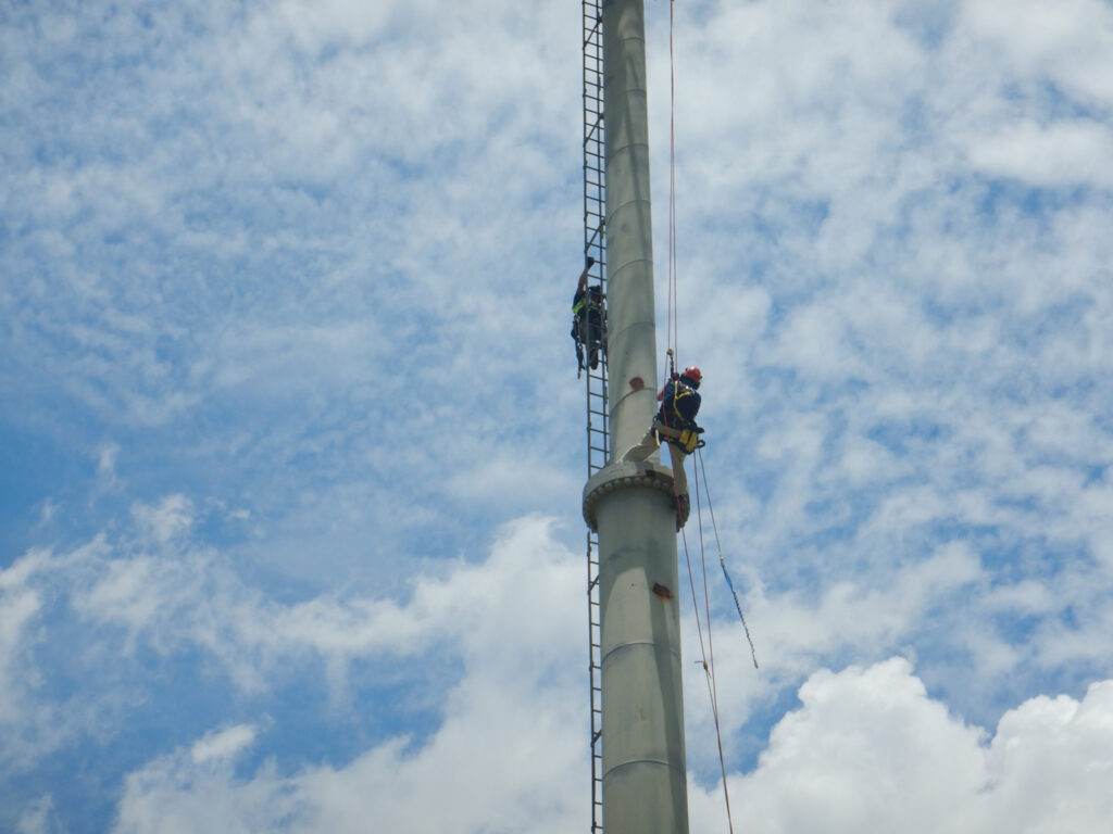 Engineers climb a tower structure