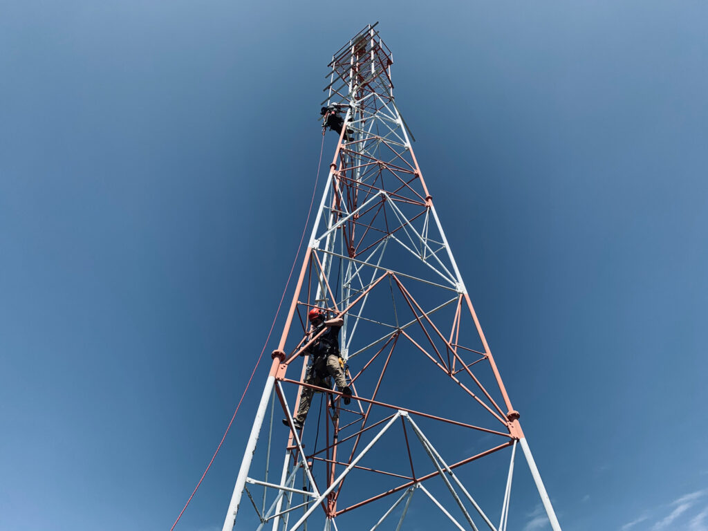 Engineers climb a tower structure